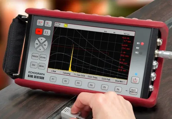 Ingeniero realizando pruebas de ultrasonido industrial con dispositivo portátil en campo.