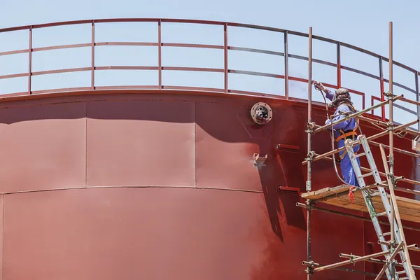 Pintura y tratamiento anticorrosivo en un tanque como parte de los servicios de mantenimiento industrial en altura.