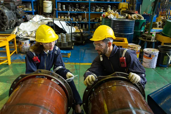 Dos ingenieros inspeccionan tuberías grandes aplicando mantenimiento predictivo industrial.