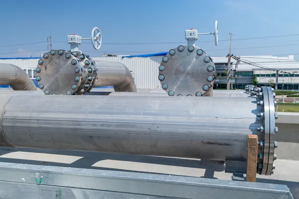 Grandes tuberías industriales con bridas atornilladas asociadas a modernos intercambiadores de calor.