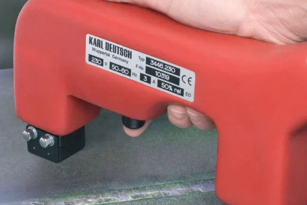 Equipo portátil en forma de U de color rojo utilizado para realizar inspección por partículas magnéticas en materiales metálicos ferromagnéticos