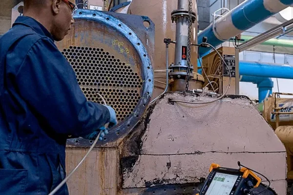 Imagen técnica de ingeniero ejecutando procedimiento de inspección por corrientes electromagnéticas en ensayos no destructivos industriales Ingeniero industrial realizando ensayo con corrientes electromagnéticas como parte de una evaluación técnica mediante ensayos no destructivos